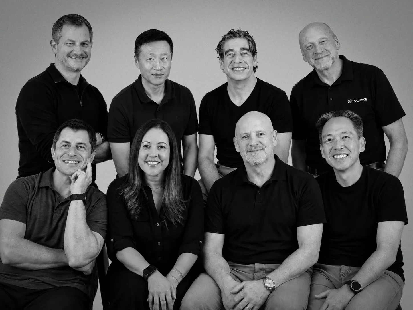 Eight members of the Cylake team, four standing behind four seated.